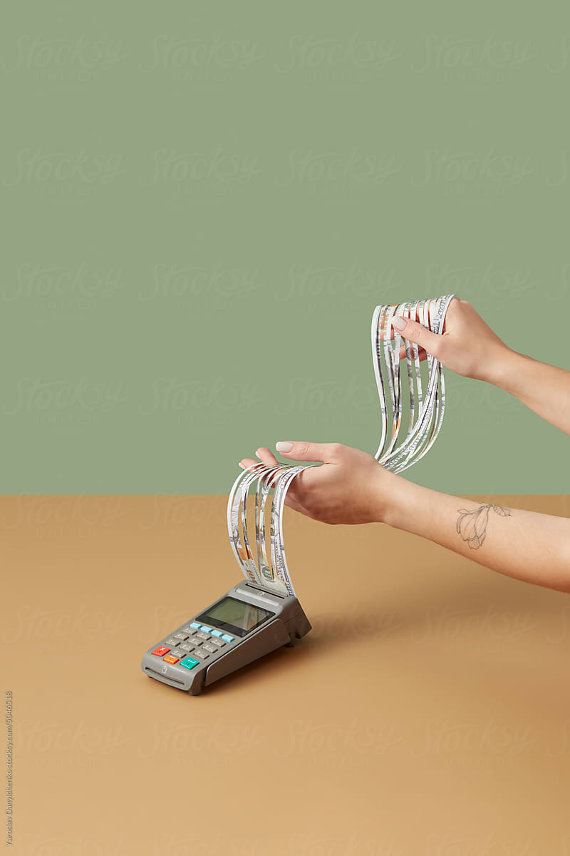 Dollar receipt in payment terminal held by hands.