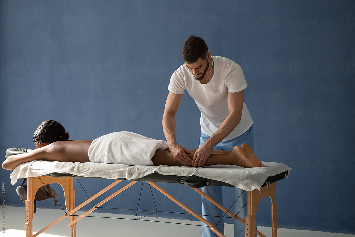 Massage therapist pinching tense calf muscles