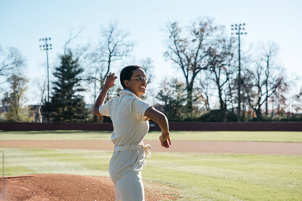 Young woman pitching a baseball