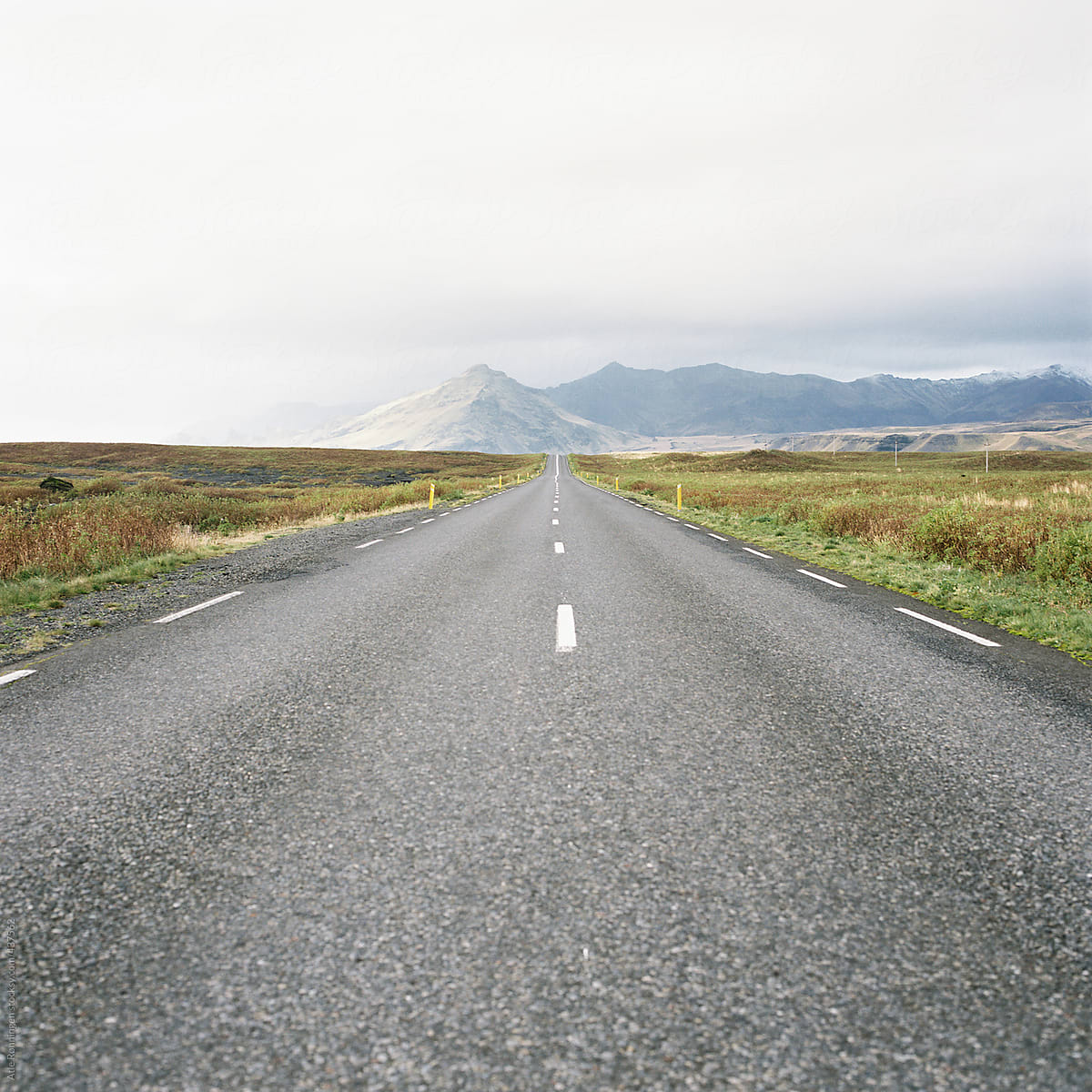 Road perspective trough the beautiful Icelandic landscape with mountains in far distance