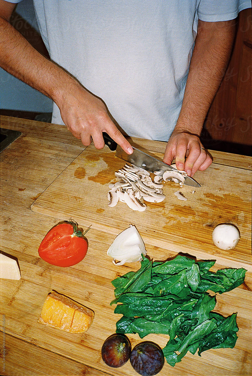 Anonymous man cutting fresh vegetables on cutting board