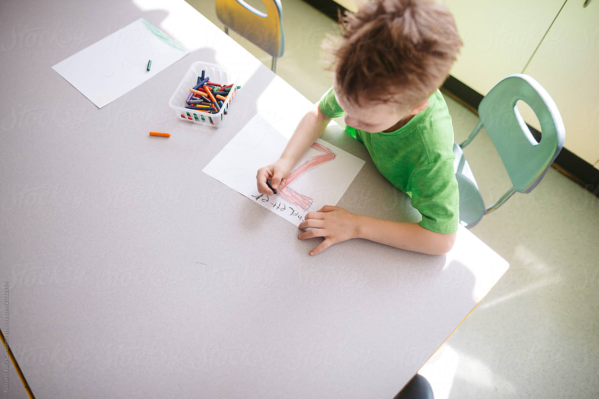 Young kid drawing in classroom