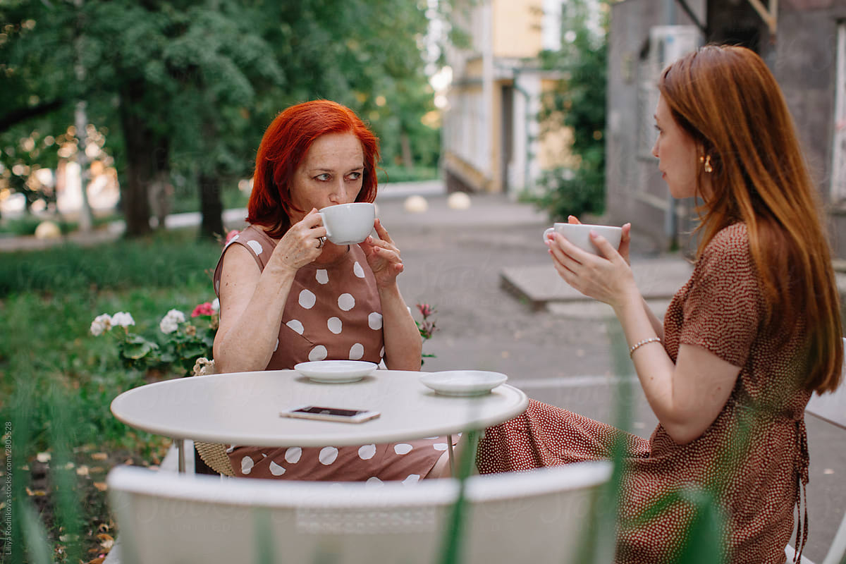 Mother with adult daughter drinking coffee