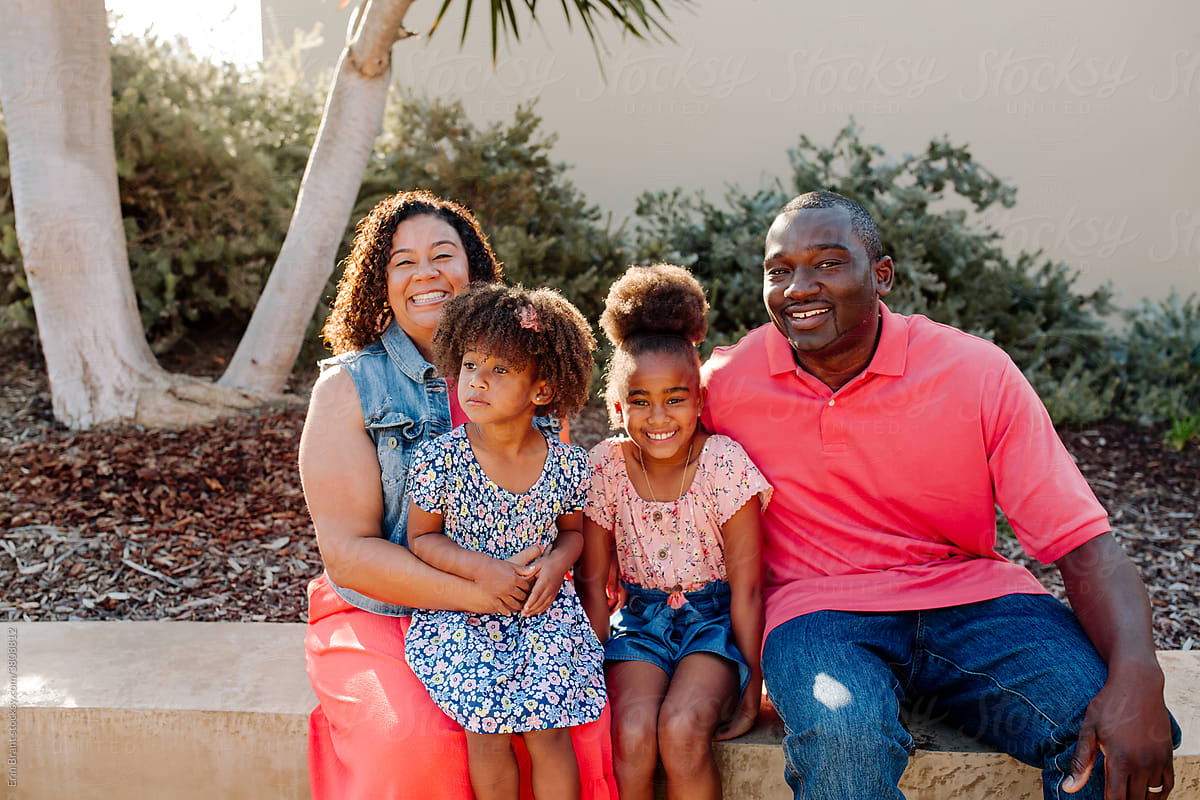Smiling Black family sitting outdoors
