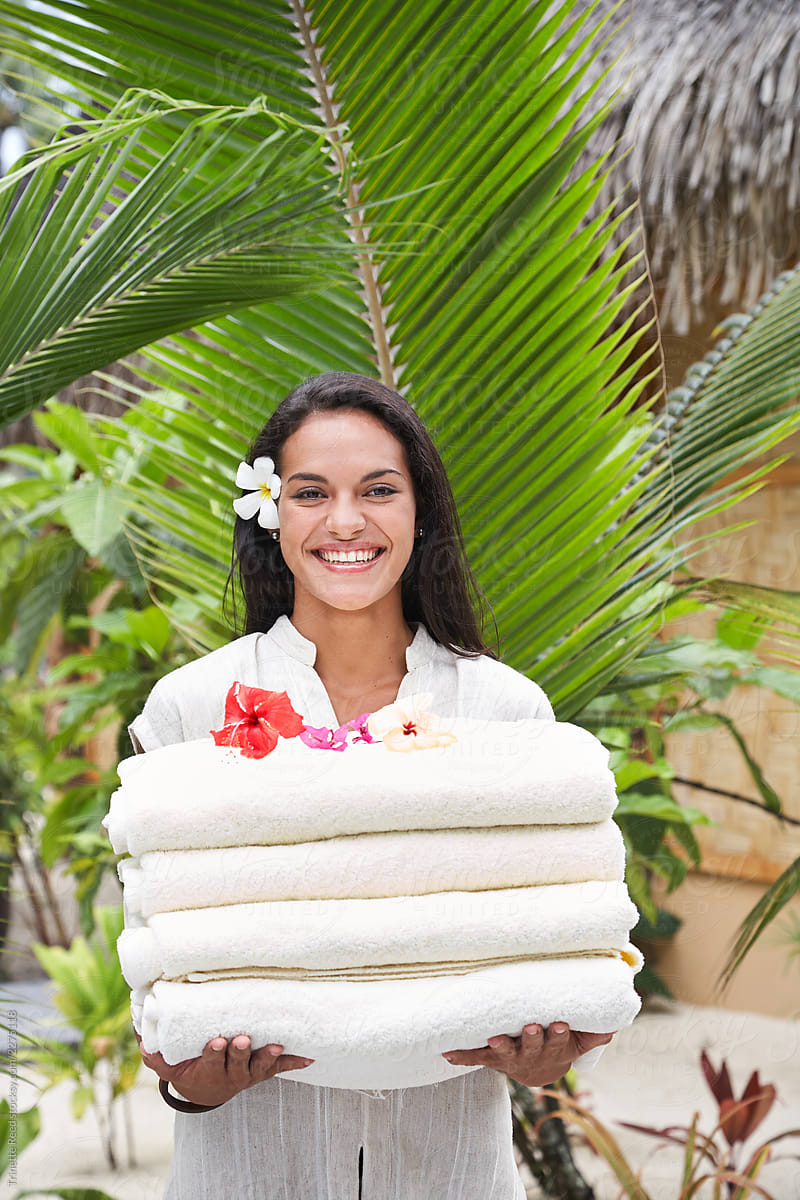 Employee holding towels at tropical spa