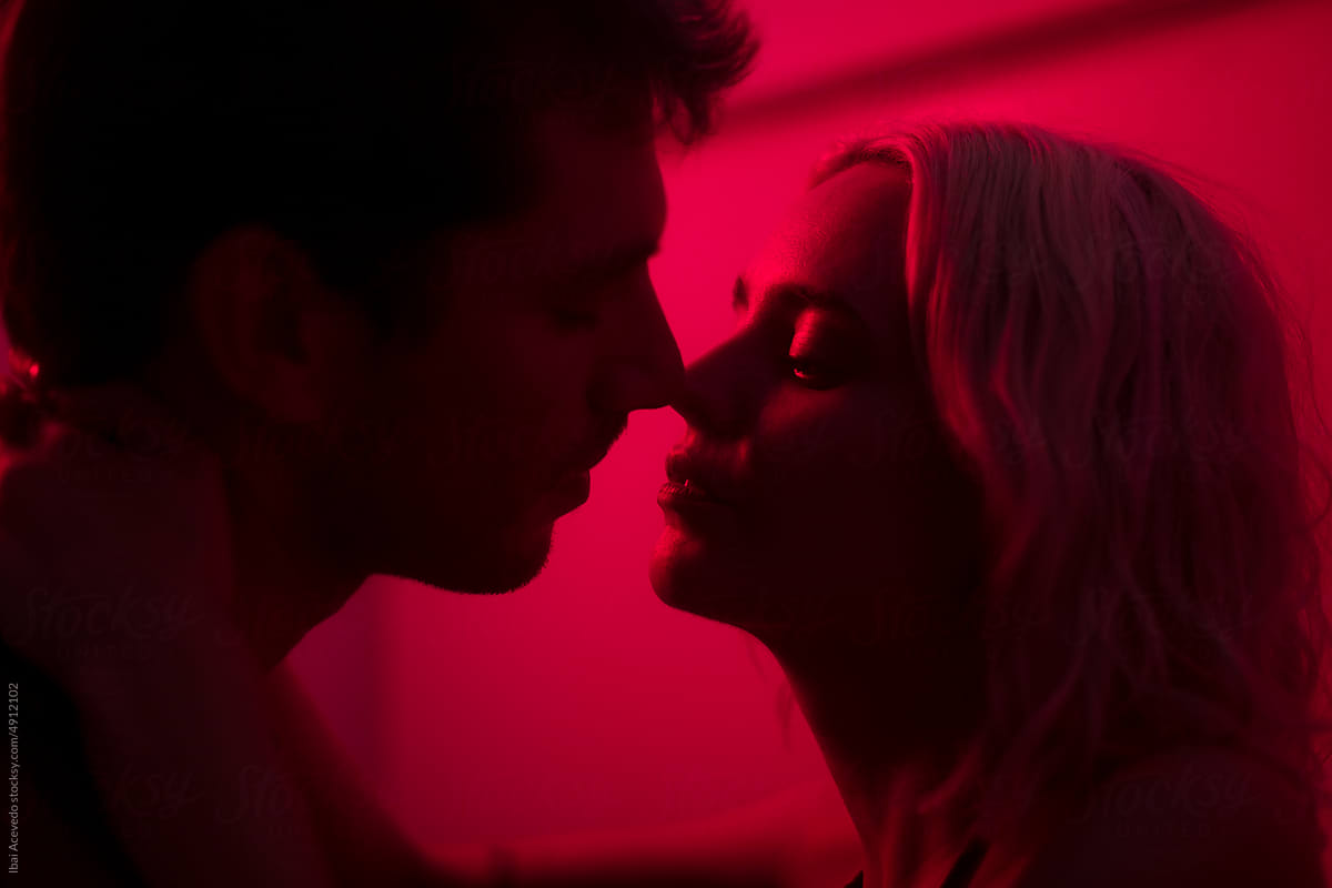 Portrait of couple kissing with red light