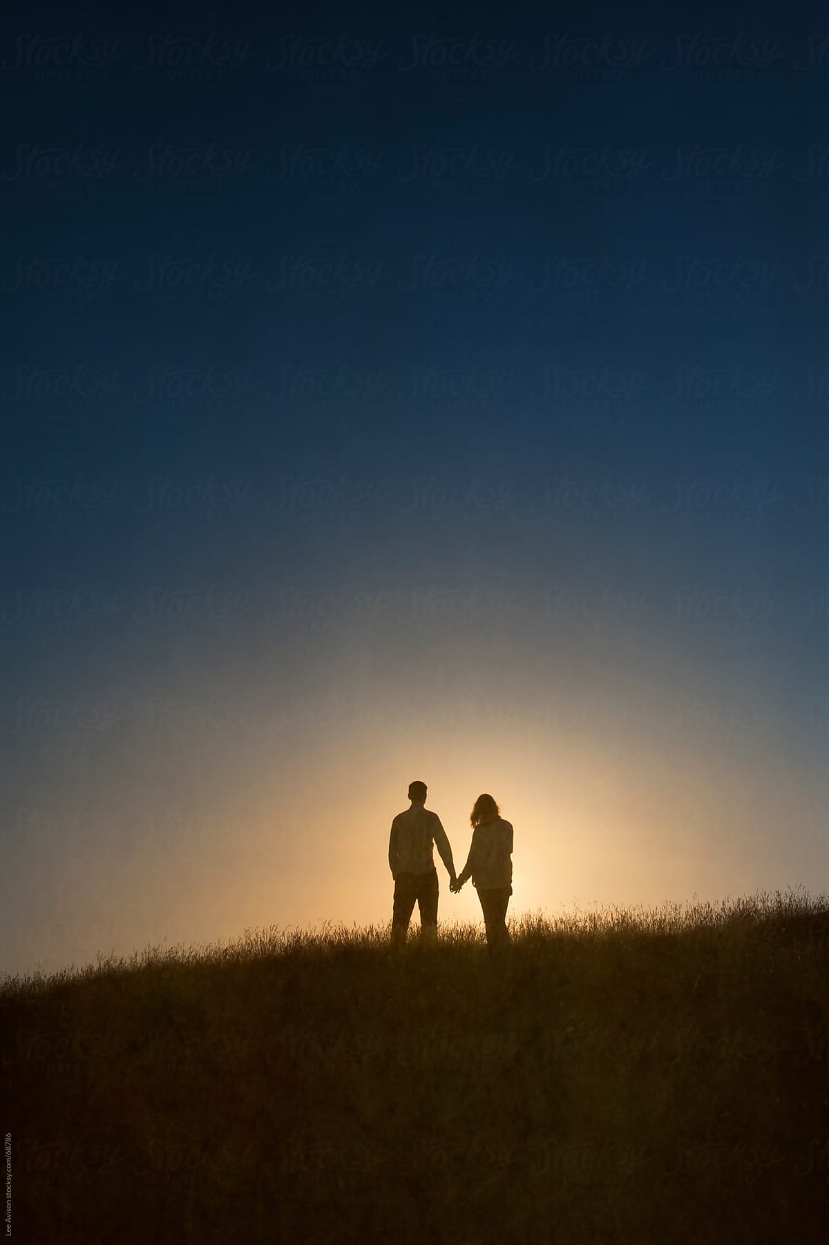 Couple Holding Hands At Sunset By Lee Avison