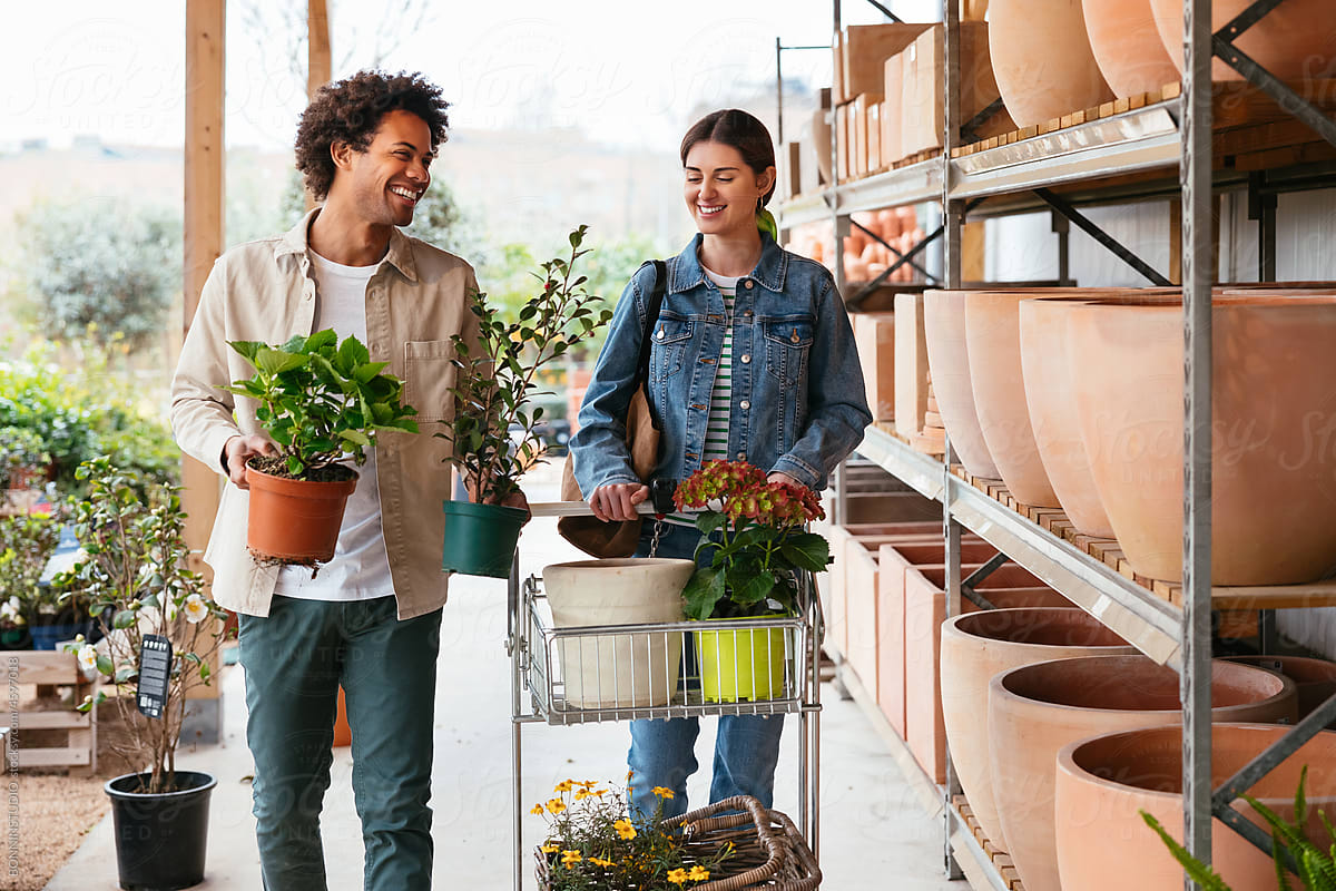 Diverse couple choosing pots for plants