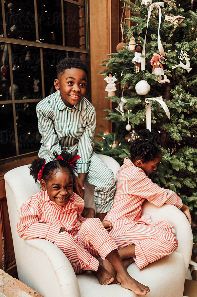 Siblings in matching pajamas during Christmas.