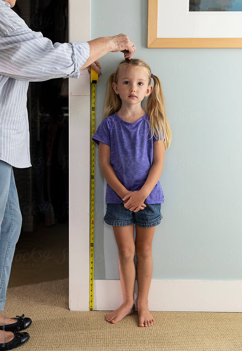 Pensive Young Girl Measuring her height
