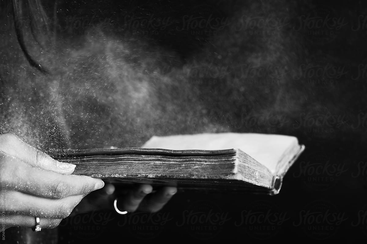 Hands of a woman opened a dusty old book.