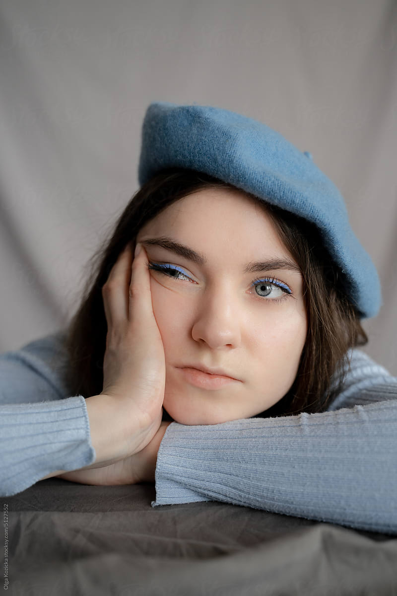 Woman In Blue Leaning On Hand Bored