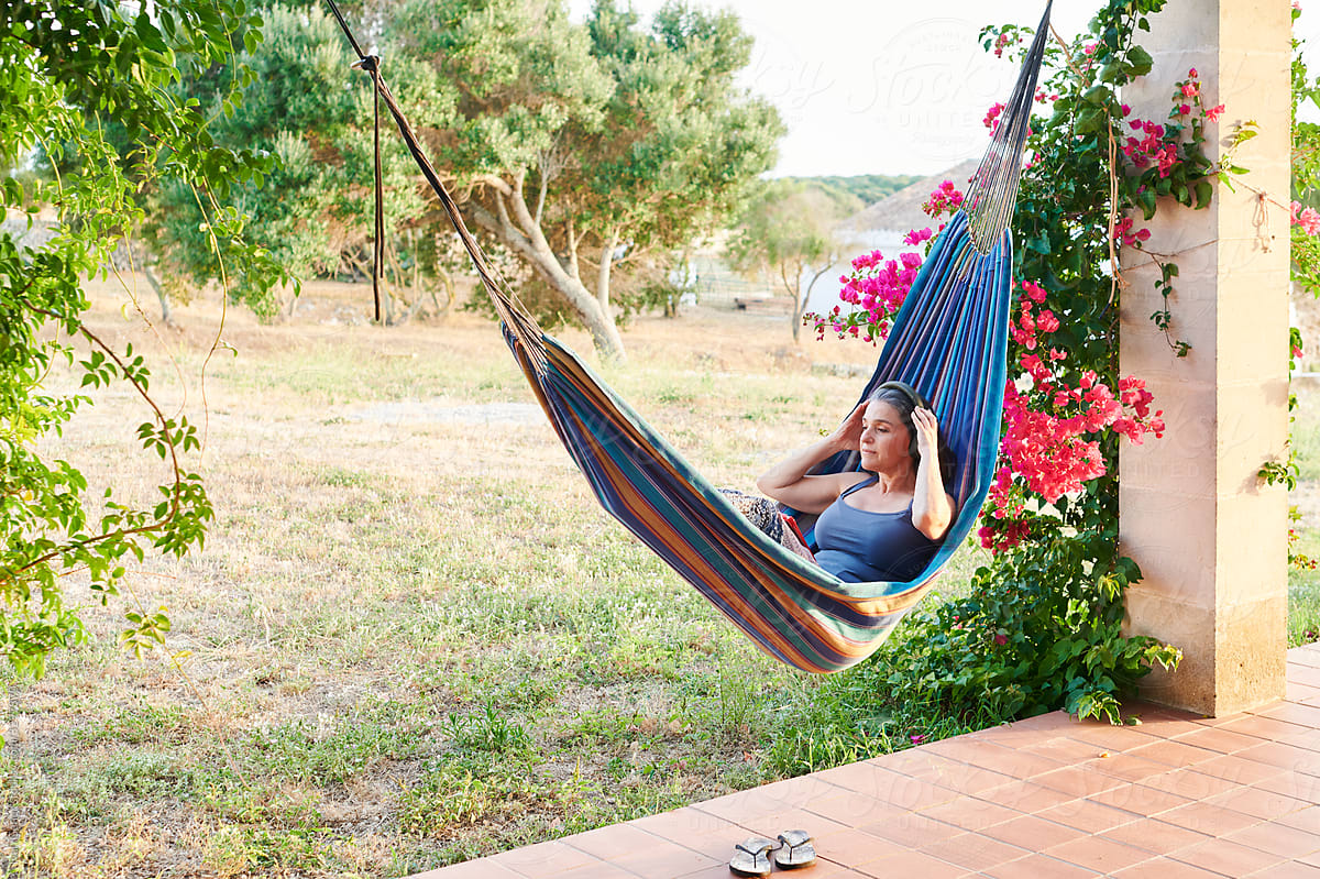 Woman wearing headphones relaxing in a hammock