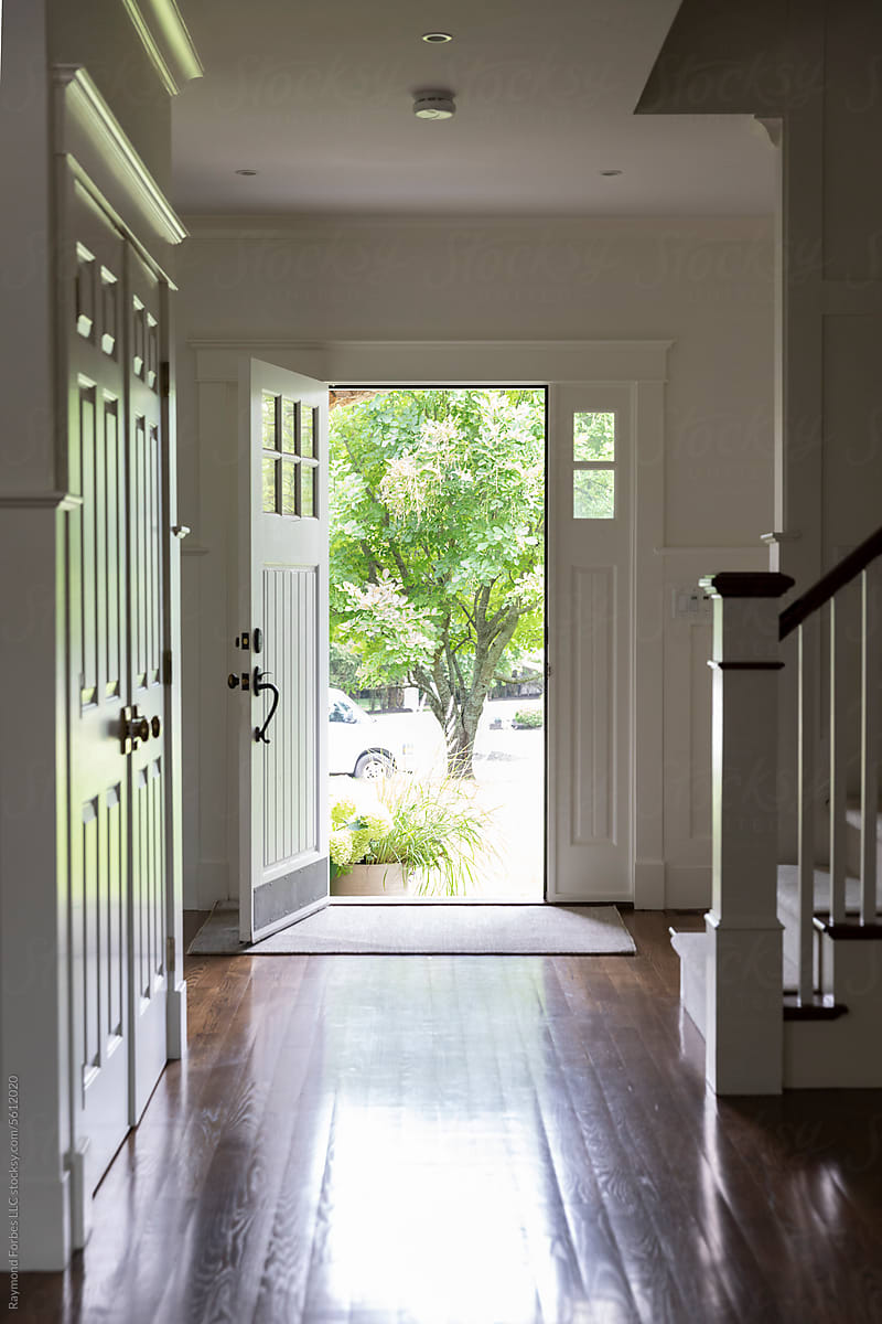 Open front of house door in foyer with staircase