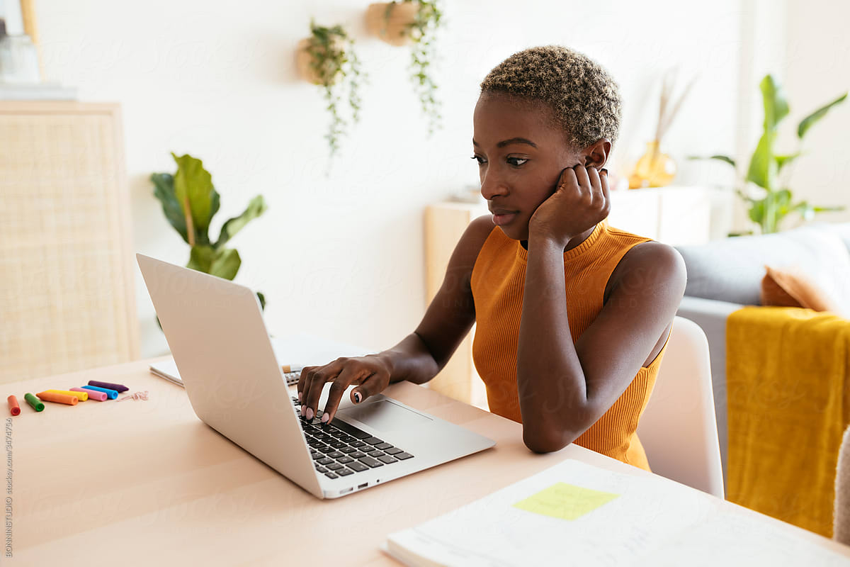 Black freelancer using laptop at home