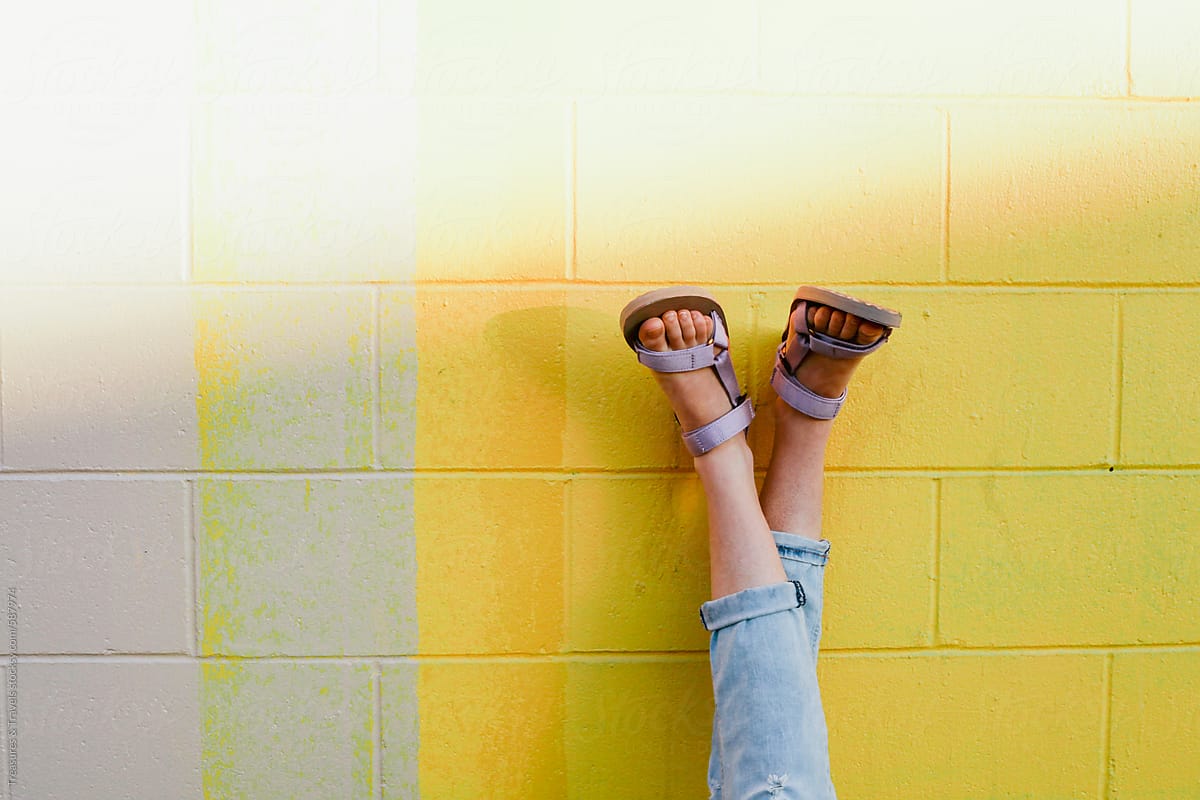 Feet & sandals on a Yellow Wall