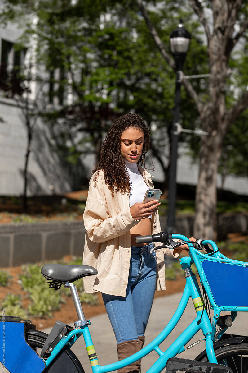 Young Woman Uses App To Rent A City Bicycle