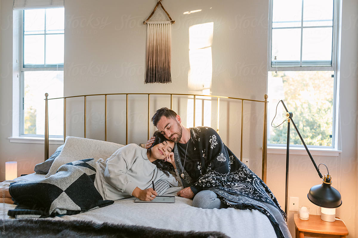 Lovely couple in love designing in boho style bedroom