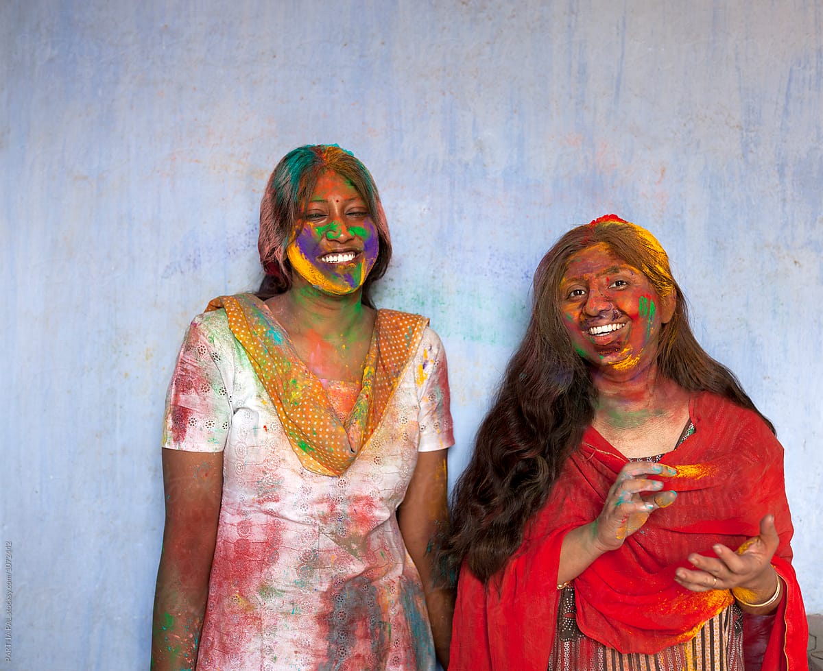 Indian woman celebrating Holi with colored spray power