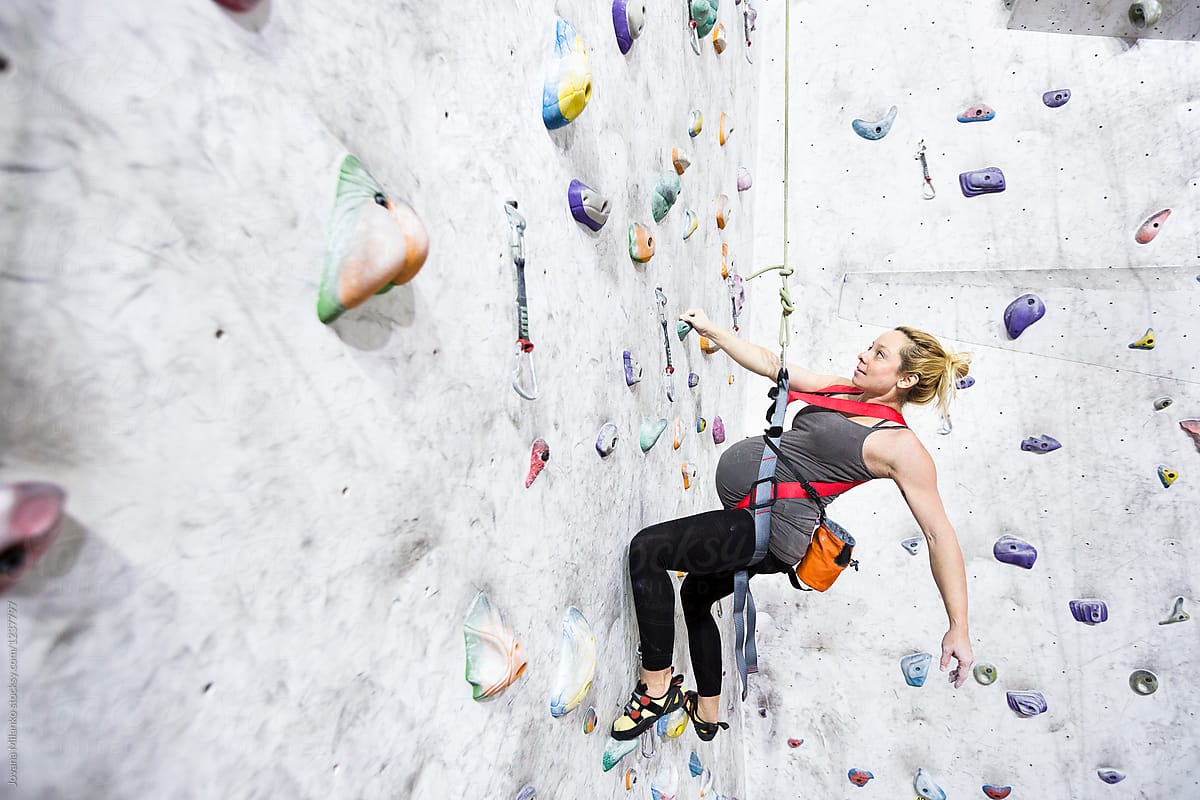 Pregnant woman rock climbing indoors