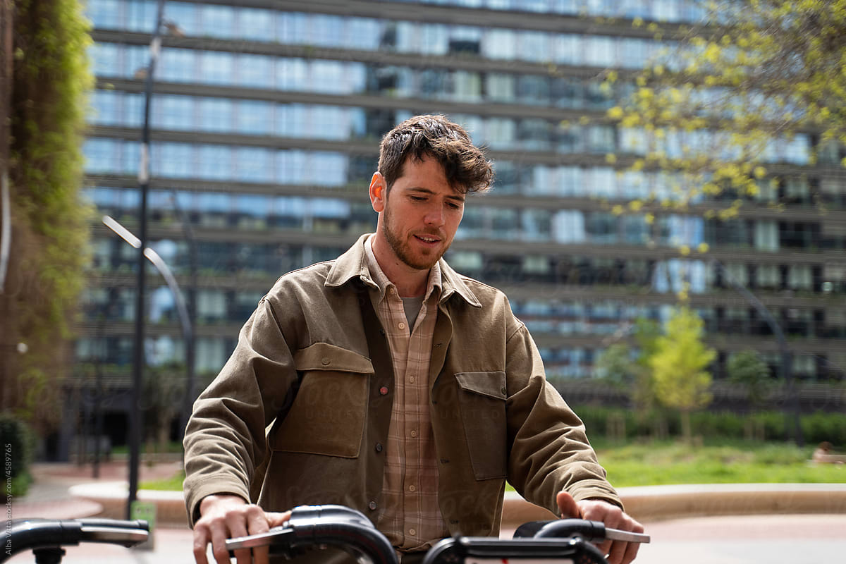 Modern man at bicycle rental parking