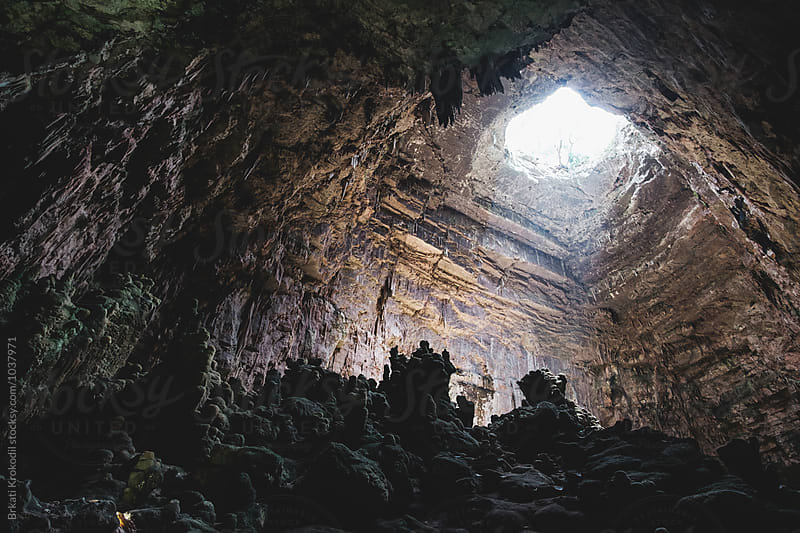 Light from above illuminates a cave