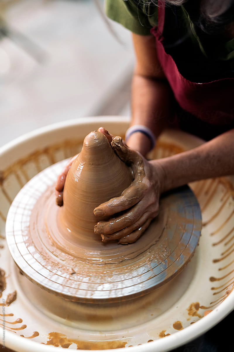 Unrecognized Person Making Pottery On Spinning Wheel