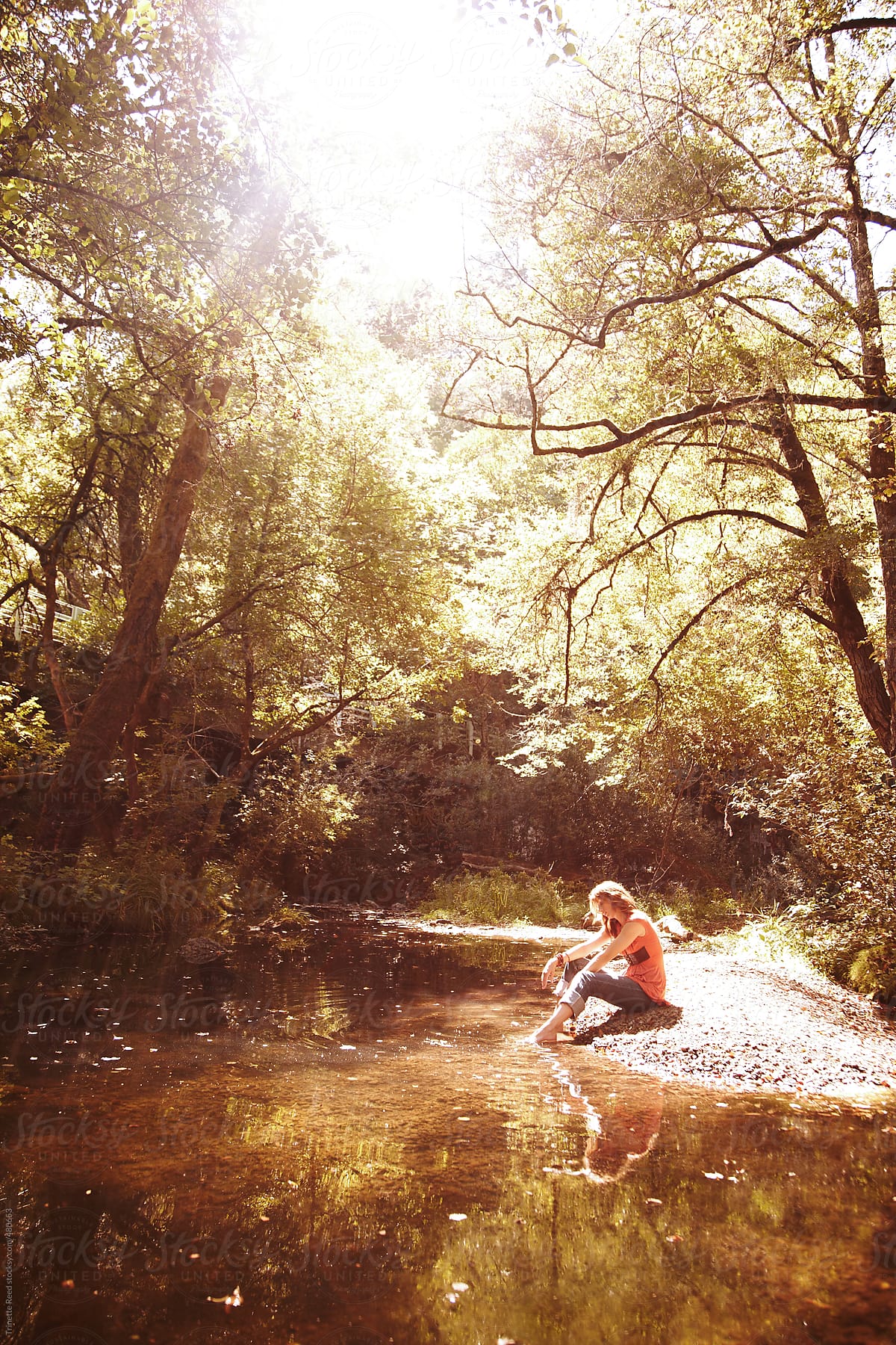 Woman relaxing in nature in the forest by a stream