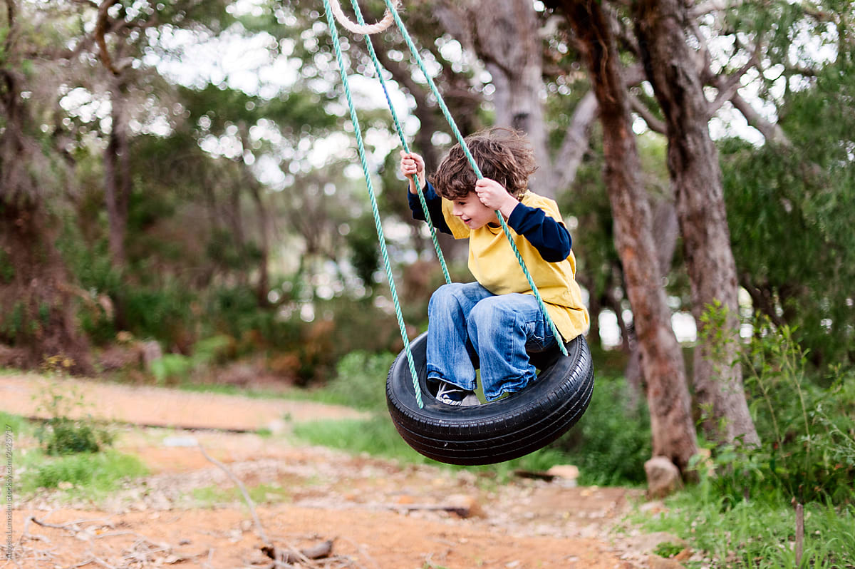 Boy swinging on a tyre swing