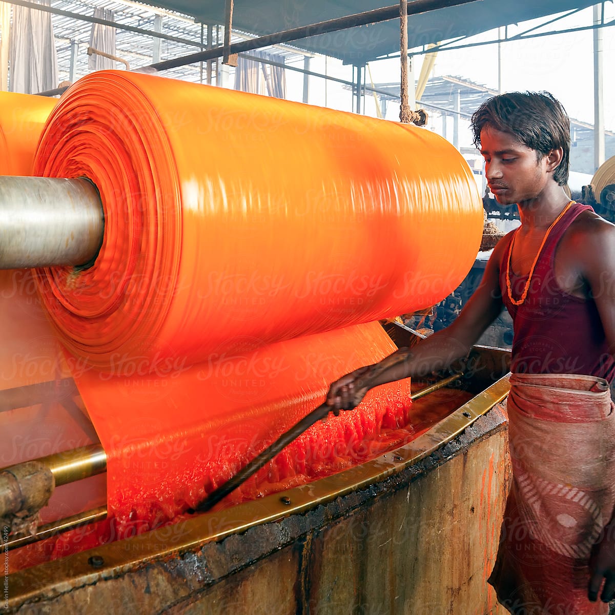 Portrait of a factory worker, Newly dyed fabric being washed and rolled, Sari garment factory, Jaipur, Rajasthan, India
