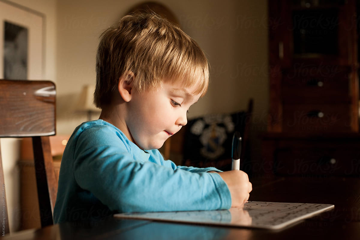 Little boy writing on a dry erase board