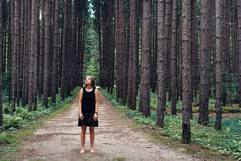 Woman in black dress on a road in the woods