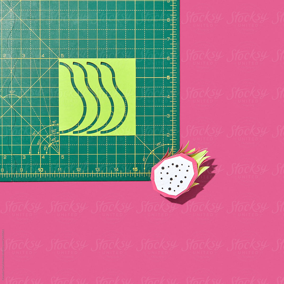 Handmade paper origami of dragon fruit and mathematical tables on a pink background.