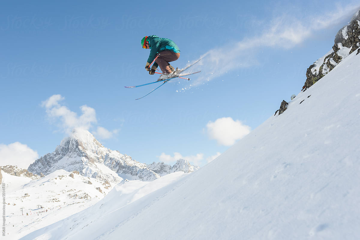 Skier Sliding Down On Steep Snow Slope by Stocksy Contributor Ibex.media  - Stocksy