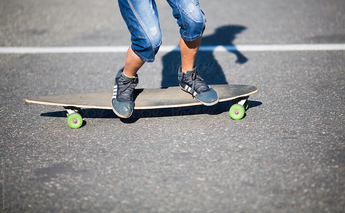 young man riding on longboard on the street