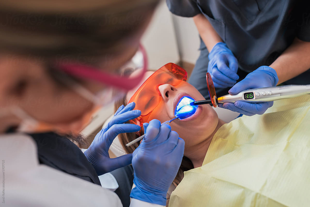 Dentist and assistant doctor during a dental intervention with a patient.