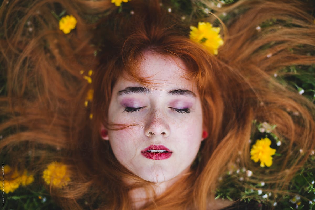 Ginger Haired Woman Laying In Flowers By Stocksy Contributor Jovana 