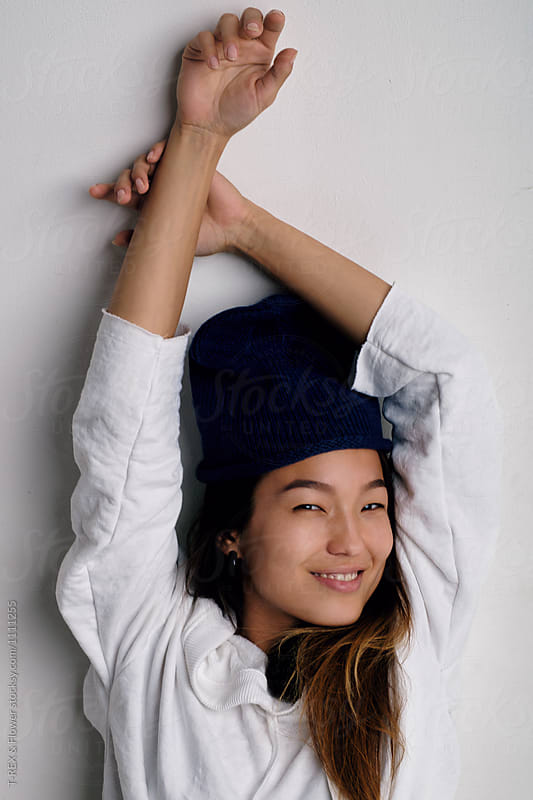 Happy Asian woman lying on white background