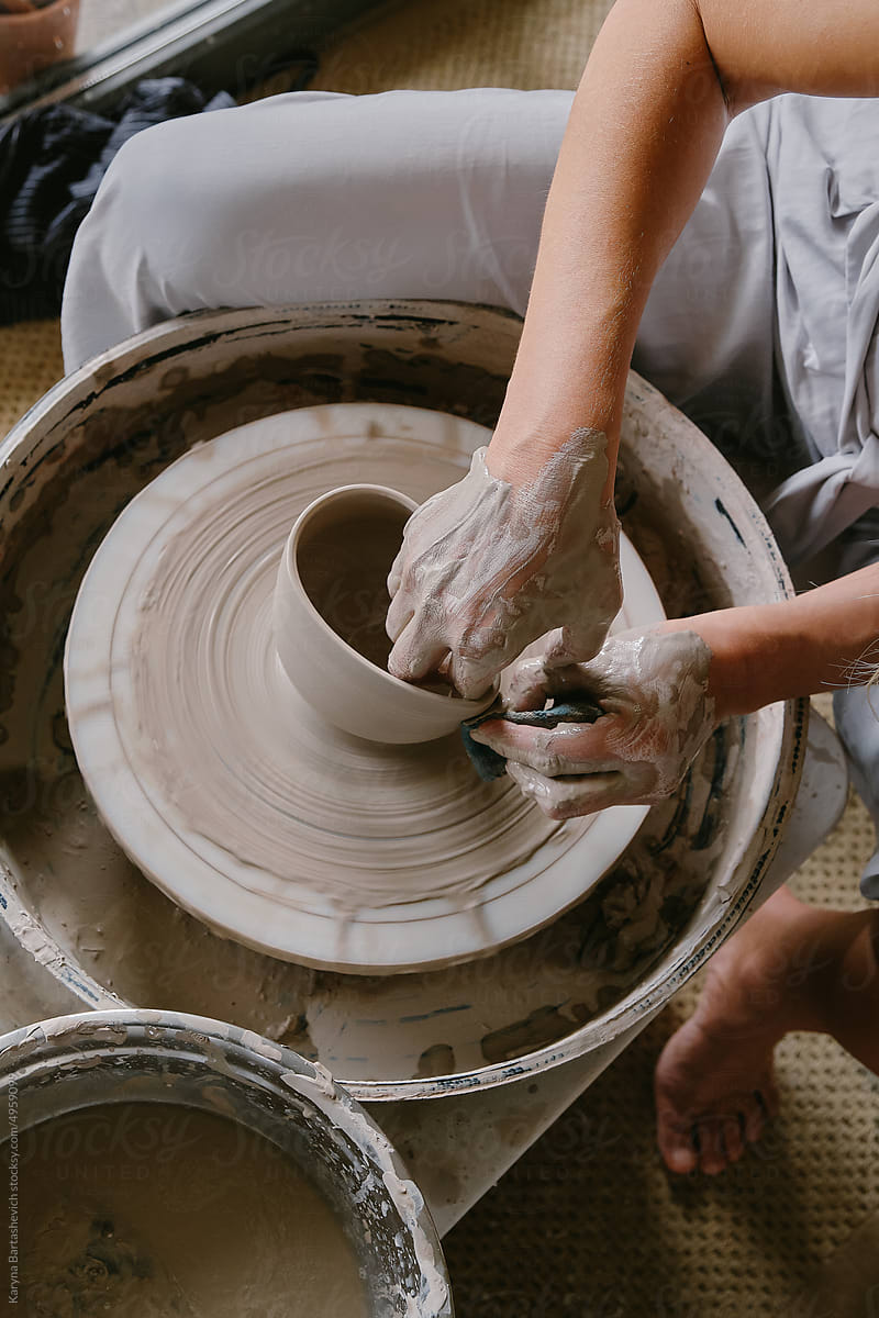 A female ceramist creates a mug made of clay.