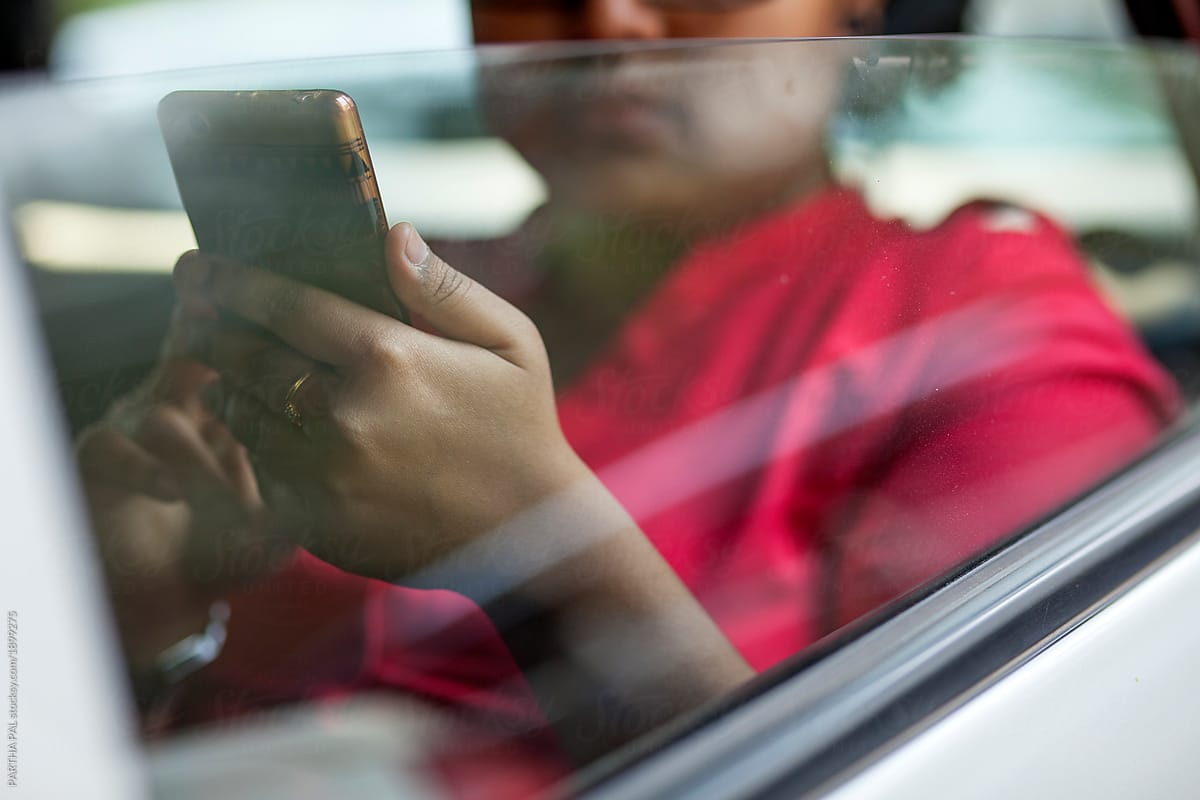 Young woman surfing mobile in smartphone inside a car