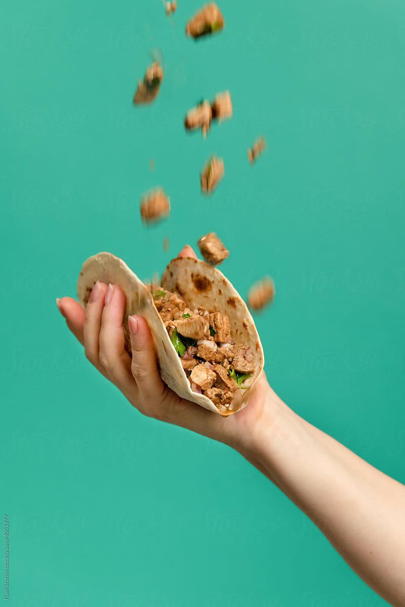 Hand holding Mexican pork tacos carnitas