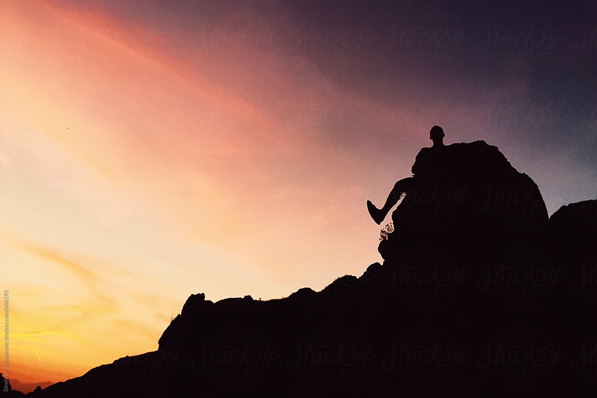 Beautiful summer sunset above the mountains with rock climber silhouette