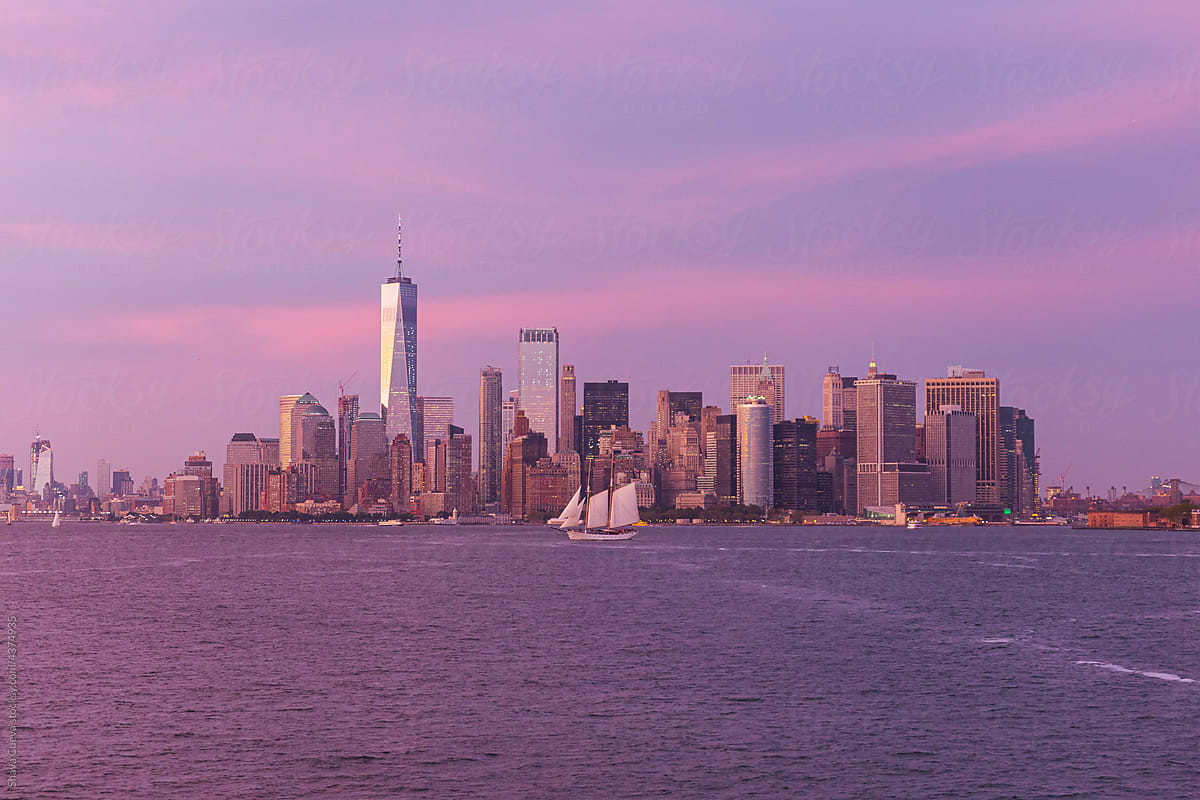 Buildings on the water in New York City during a pink sunset