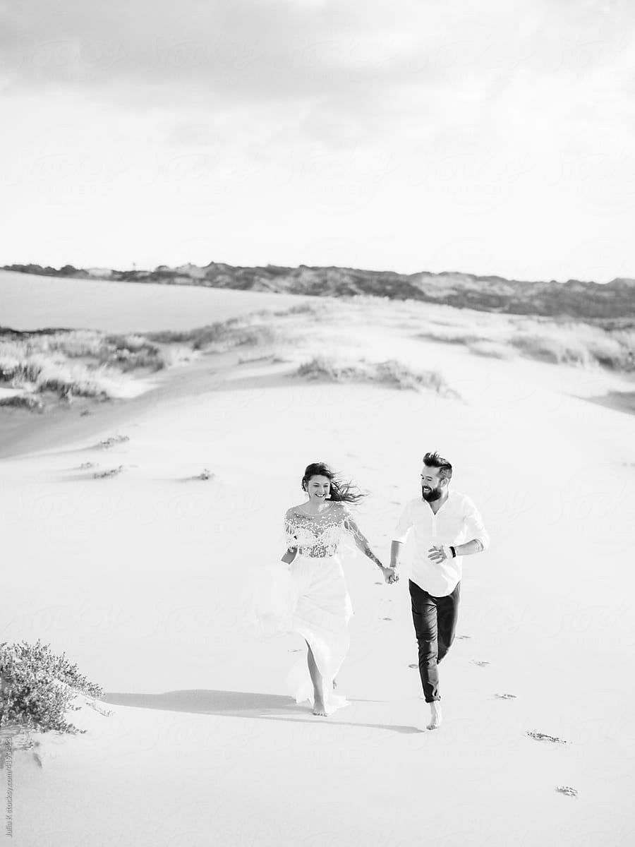 Newlyweds Running On The Beach
