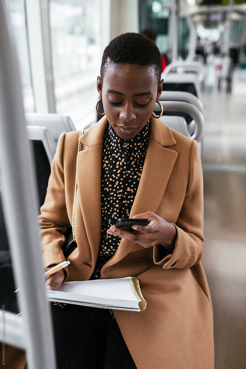 Black passenger using smartphone in modern transport