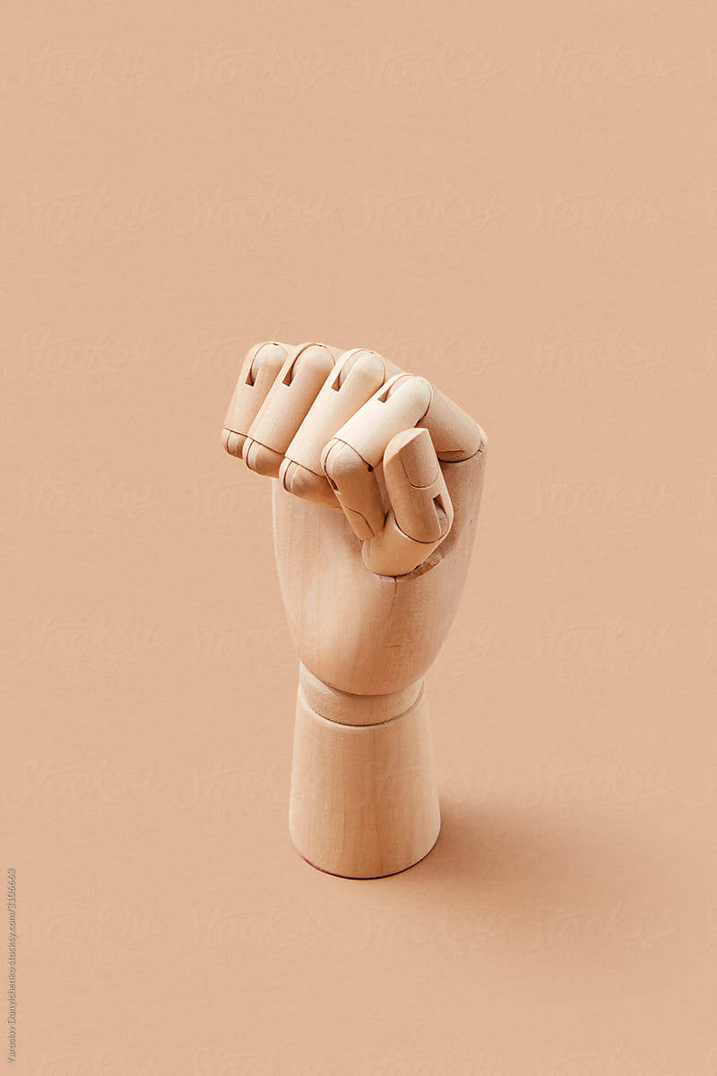 Wooden mannequin\'s hand clenched fist.