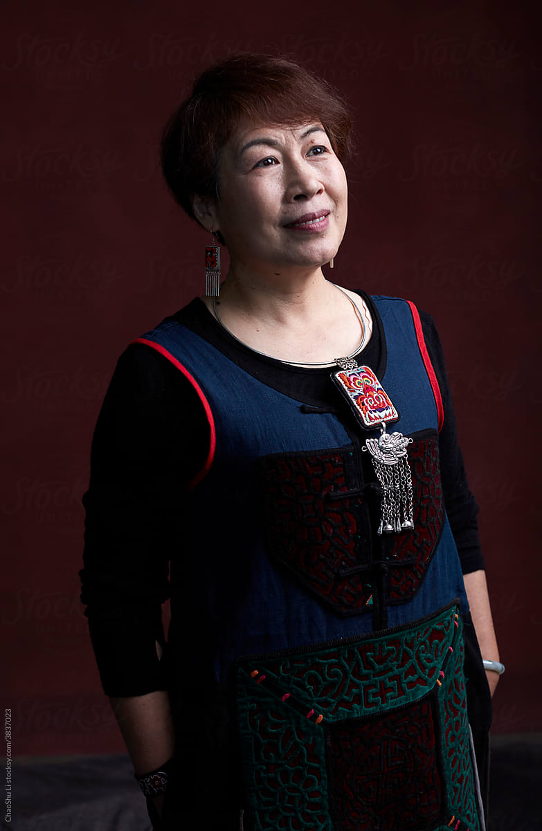 Portrait of middle-aged Asian woman, wearing traditional Chinese dress, indoors.