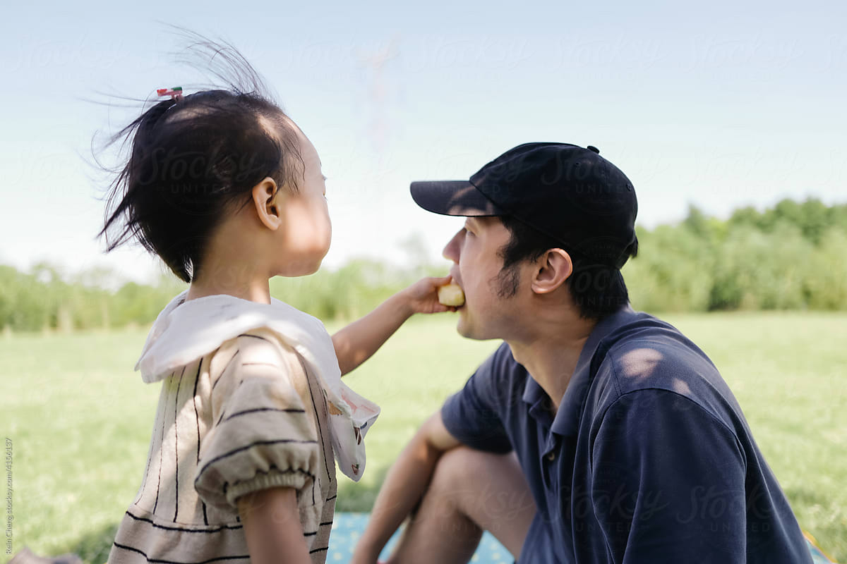 Asian father and daughter having picnic together