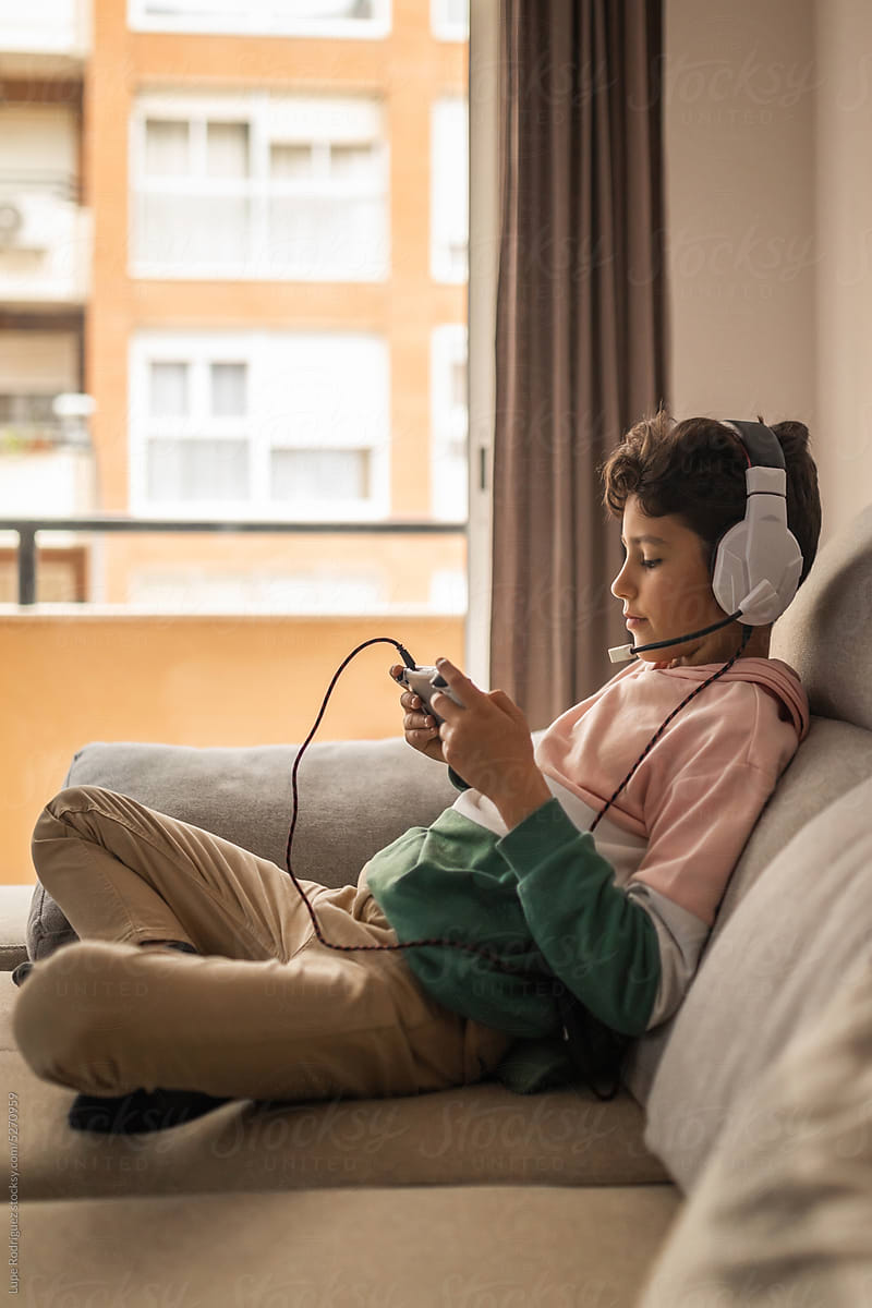boy playing console at home