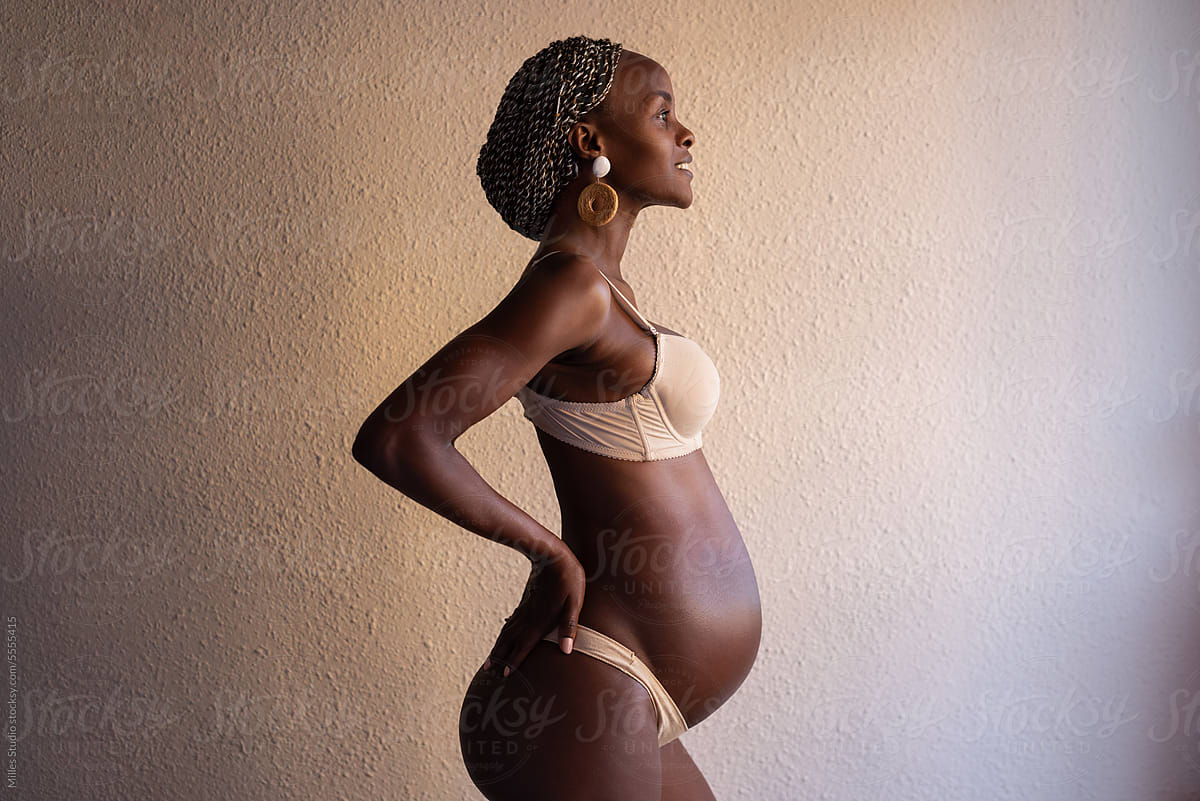 Happy black pregnant woman wearing underwear